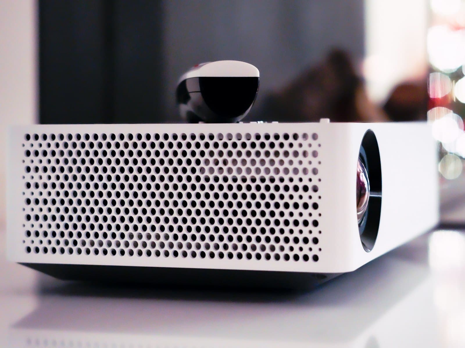 Aurea P300 projector shown front-on, matt white body with a central lens